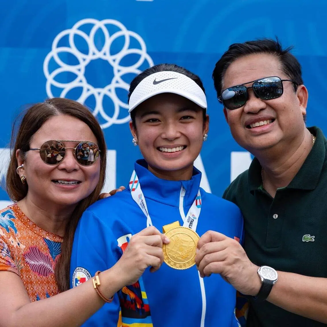 Alexandra Eala (centre) posing with her SEA Games women's singles medal with her mother Rizza Maniego-Eala (left) and father Mike on Dec 18, 2025.