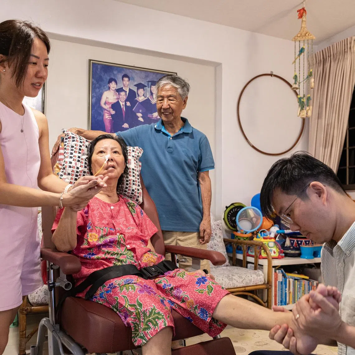 Mr Alvin Yap (from right) stays with his father Mr Ron Yap, and mother Mdm Cecilia Wong. His sister, Ms Kimberly Yap, also visits everyday to care for their parents. The family receives $1,800 of financial aid from the government each month, which helps in the management of the long-term care costs.