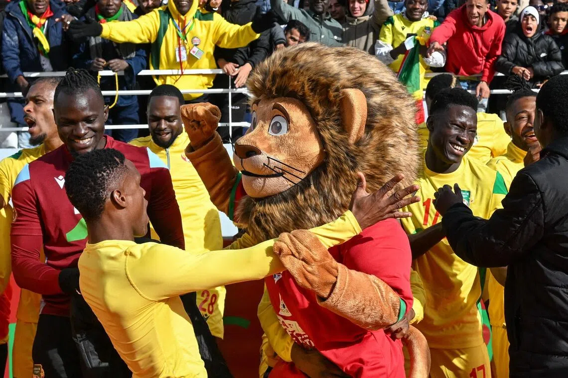 Benin's players celebrate with Assad, the Africa Cup of Nations official mascot, after a 1-0 win over Botswana in their Group D football match at Rabat Olympic Stadium on Dec 27, 2025.