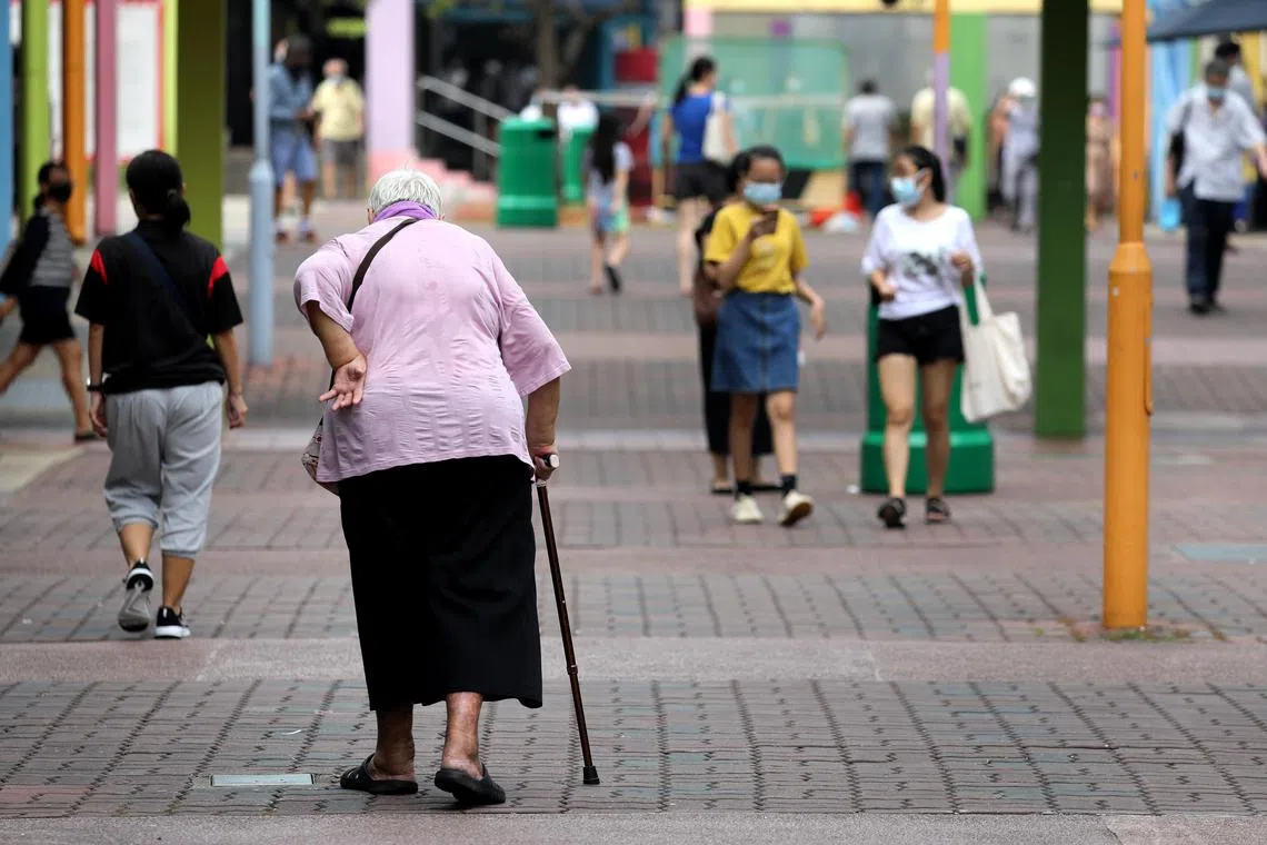 疫情下，行动不便年长者拄着拐杖外出。老人背影。Old woman walking with the aid of a walking stick.