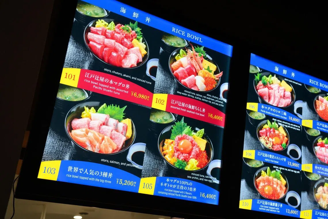 Digital menu boards display dishes at Edo Tsujiya seafood restaurant inside Toyosu Senkyaku Banrai retail complex in Tokyo.