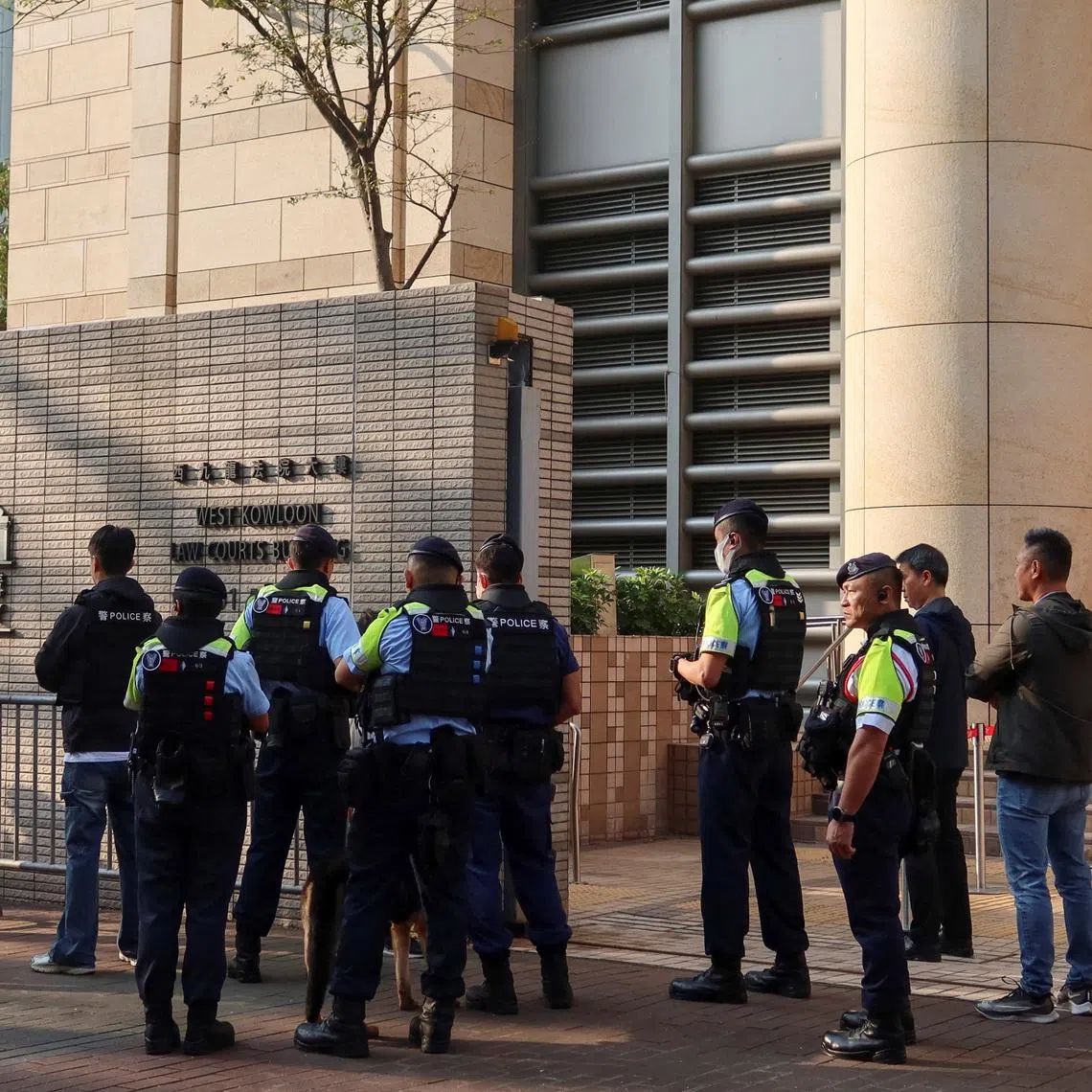 Police stand guard outside the West Kowloon Magistrates’ Courts in Hong Kong.