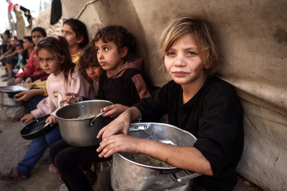 Palestinian children collecting food aid at a refugee camp in the central Gaza Strip, on Nov 6.