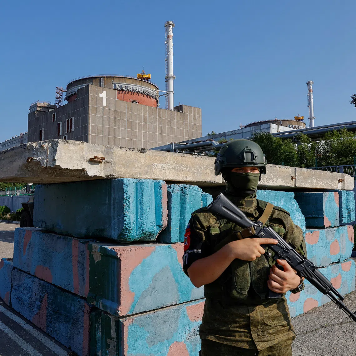 FILE PHOTO: A Russian service member stands guard at a checkpoint near the Zaporizhzhia Nuclear Power Plant before the arrival of the International Atomic Energy Agency (IAEA) expert mission in the course of Russia-Ukraine conflict outside Enerhodar in the Zaporizhzhia region, Russian-controlled Ukraine, June 15, 2023. REUTERS/Alexander Ermochenko/File Photo
