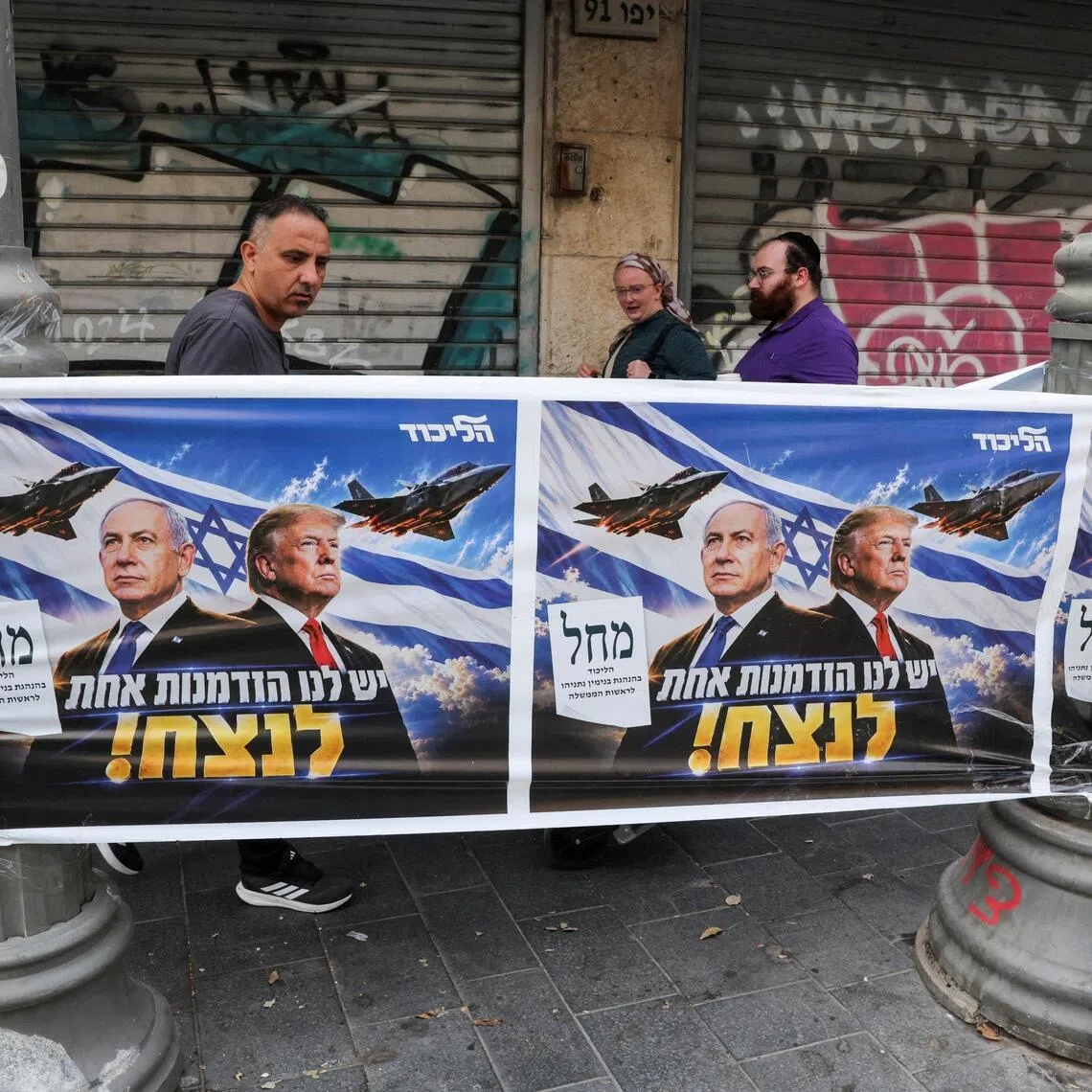 People walk past a poster of Israeli Prime Minister and Likud party leader Benjamin Netanyahu and US President Donald Trump during the country's national elections in central Jerusalem, October 27, 2026. REUTERS/Kevin Coombs

     TPX IMAGES OF THE DAY