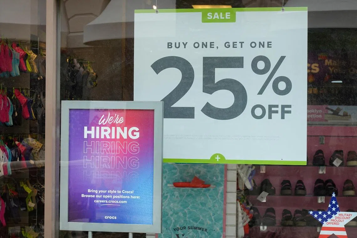 FILE PHOTO: Employment sign and sale sign are displayed at a retail store in Carlsbad, California, U.S., May 25, 2023. REUTERS/Mike Blake/File Photo