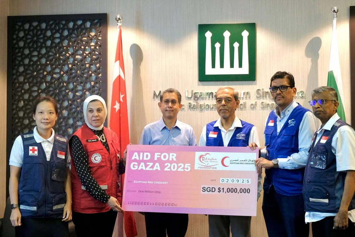 Dr Amal Emam, the chief executive of the Egyptian Red Crescent (in red), receiving the mock cheque from Rahmatan Lil Alamin Foundation chief executive Adnan Abdul Hamid (second from right) in a ceremony witnessed by Acting Minister-in-charge of Muslim Affairs Faishal Ibrahim on Sept 2.