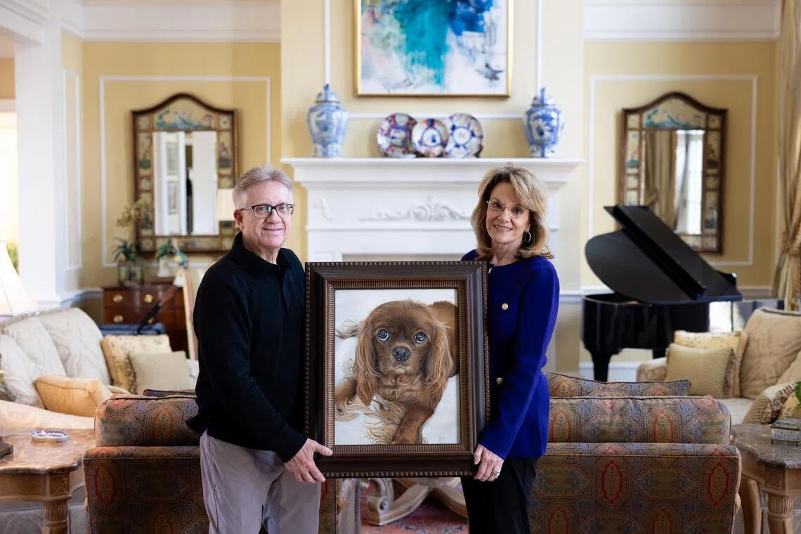Tonya and Larry Smith hold a commissioned portrait of their King Charles Spaniel, Rusty, who passed away in November at their home in Quitman, Ga., on March 19, 2026. Commissioned pet portraits have been around for centuries, but now they’re reaching a much wider clientele. (Erich Martin/The New York Times)