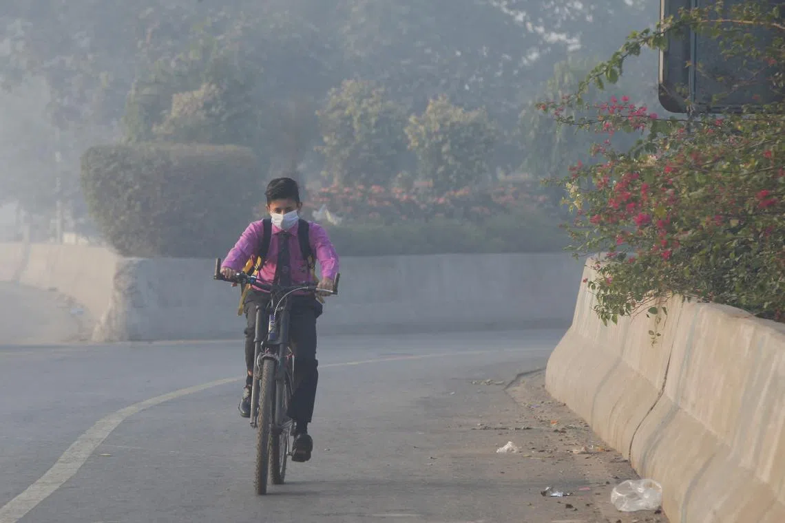 Student rides a bicycle to school amid dense smog in Lahore, Pakistan November 24, 2021. REUTERS/Mohsin Raza/File Photo