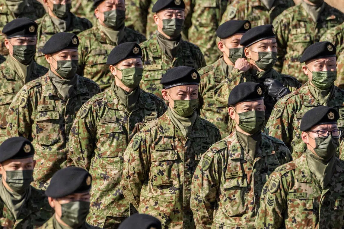 Japan's Ground Self-Defence Force 1st Airborne Brigade personnel stand in formation during the defence minister's speech following in a joint military exercise among Japan, the US, Britain and Australia at Narashino exercise field in Funabashi of Chiba prefecture on January 8, 2023. (Photo by Yuichi YAMAZAKI / AFP)
