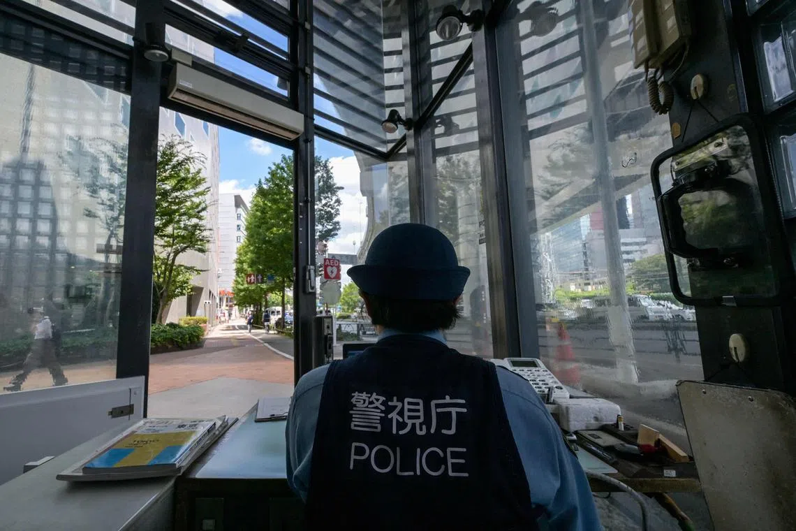 A police officer works inside a koban, or police box, in the Iidabashi district of central Tokyo.