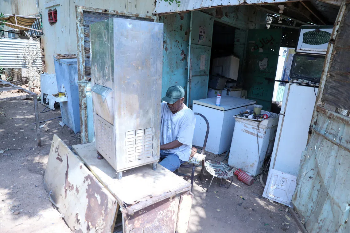 A refrigerator maintenance technician repairs a refrigerator in a neighborhood in Omdurman, Sudan, August 20, 2026. REUTERS/El Tayeb Siddig