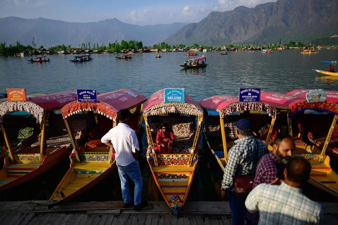 Tourists ride Shikara, a traditional wooden boat at the iconic Dal Lake in Srinagar.