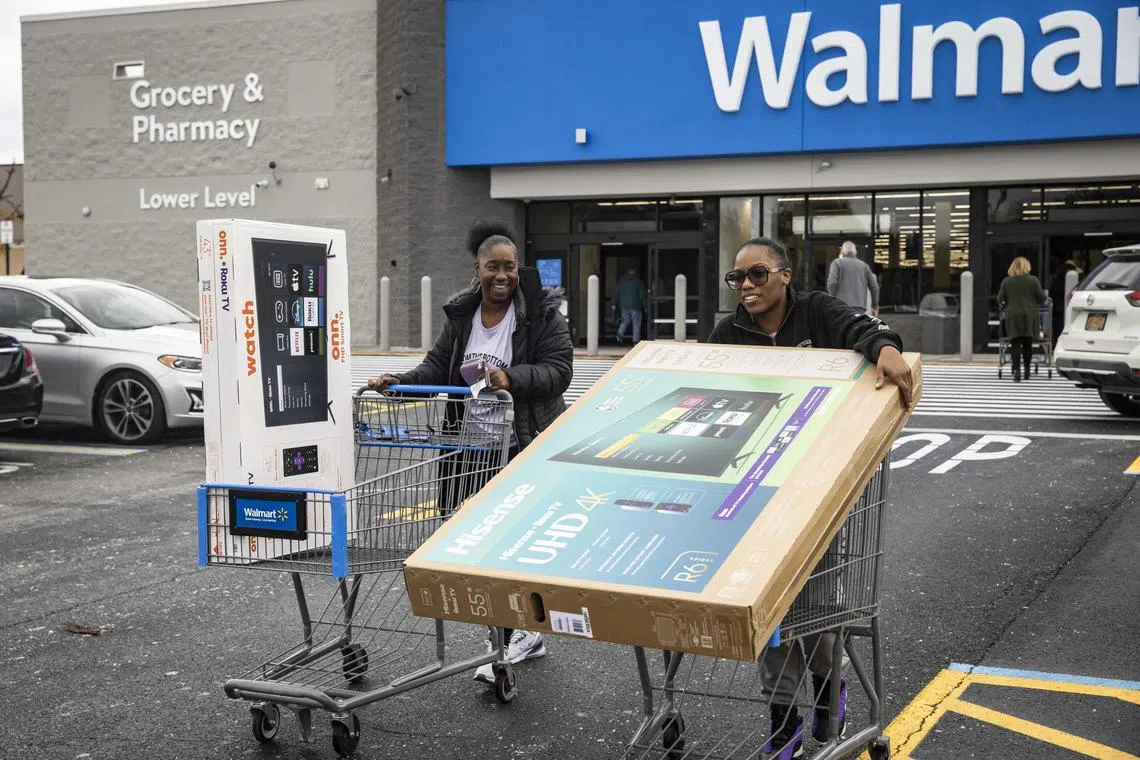 Angela Scott (left) and Screll Royal exiting a Walmart Supercenter with televisions on Black Friday in Albany, New York on Nov 29. Preliminary data released on Nov 29 suggests that Americans took advantage of big deals on Thanksgiving and Black Friday, opening their wallets, though they were selective about what they bought.