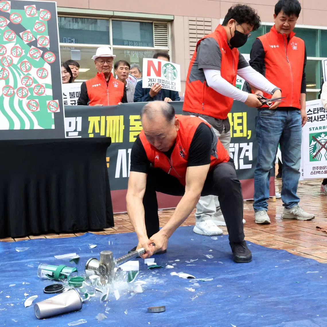 An activist smashes Starbucks products during a protest against Starbucks' Tank Day campaign, which evoked memories of the military crackdown on the 1980 Gwangju democratic uprising, in Gwangju on May 21.