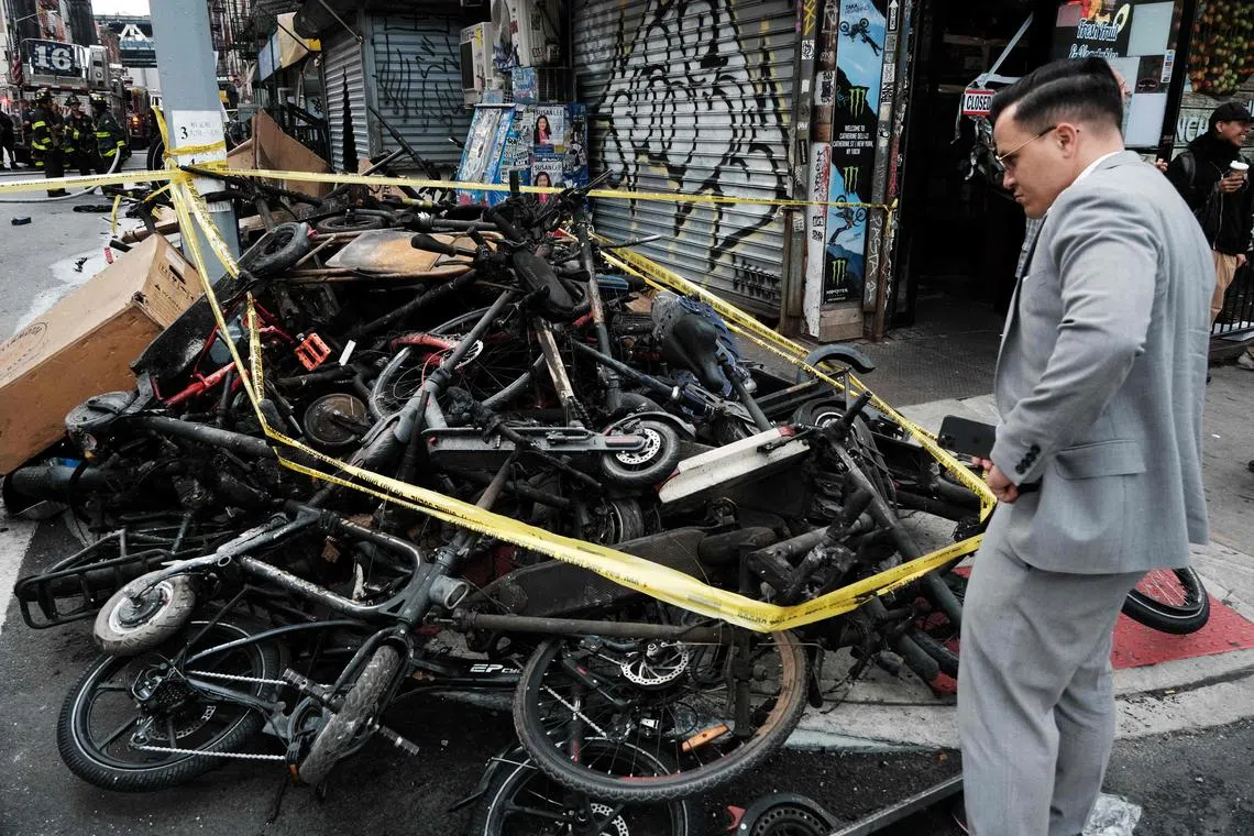 Charred remains of e-bikes and scooters sit outside of a building in Chinatown in New York City.