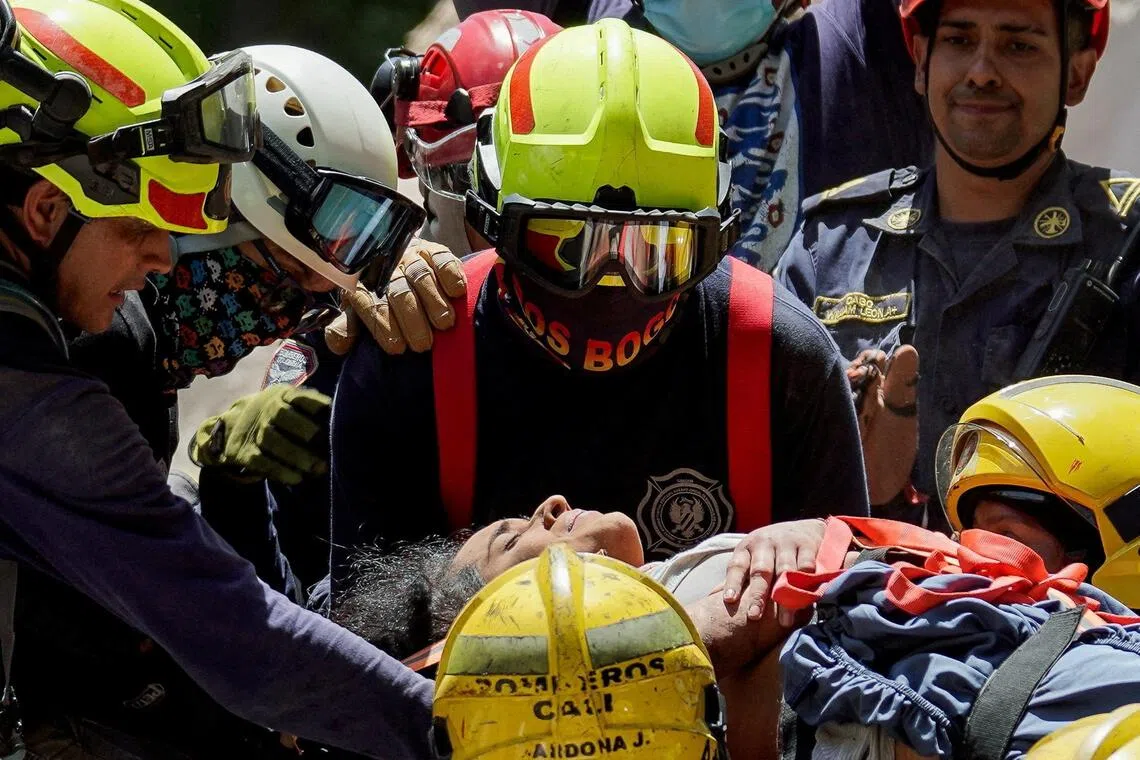Rescuers carrying earthquake survivor Diana Troncoso from the debris of a collapsed building in Cali, Colombia, on Aug 11.