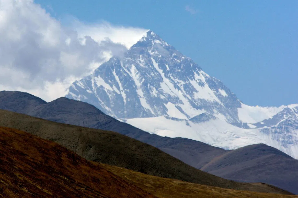 FILE PHOTO: Mount Everest, known in Tibetan as Qomolangma, rises behind foothills, as seen from near the Tibetan town of Shegar, April 27, 2008. REUTERS/David Gray/File Photo