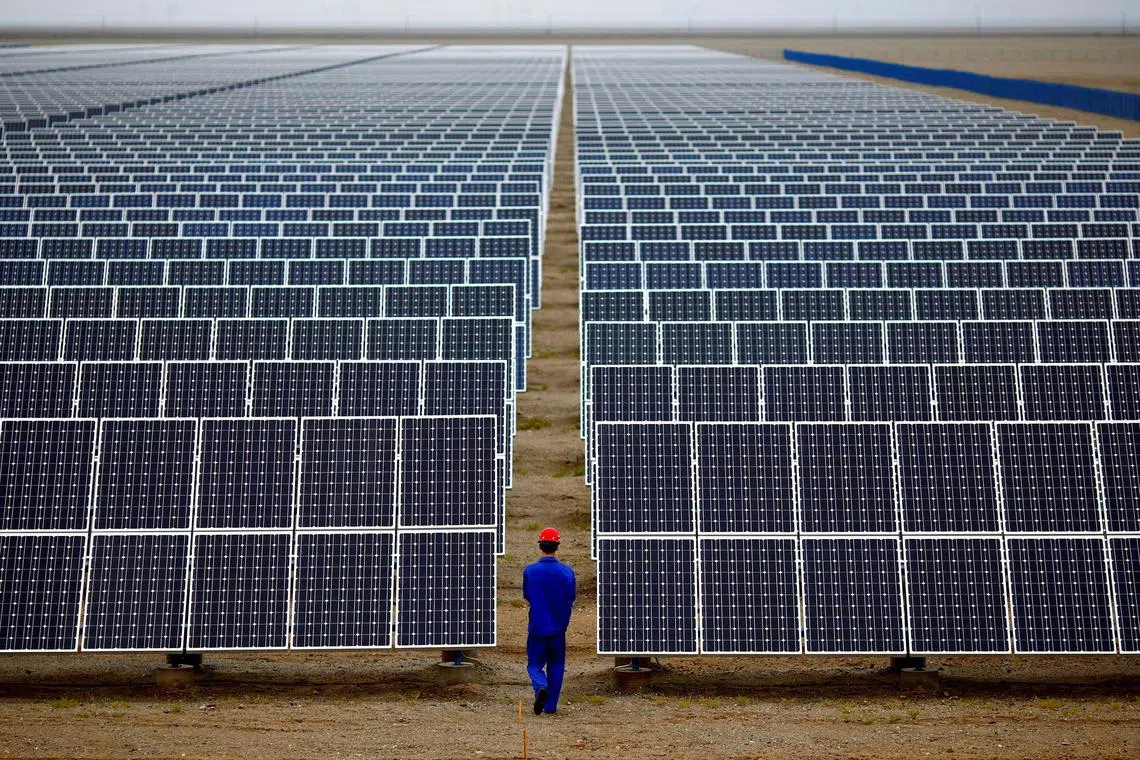 FILE PHOTO: A worker inspects solar panels at a solar Dunhuang, 950km (590 miles) northwest of Lanzhou, Gansu Province September 16, 2013. REUTERS/Carlos Barria//File Photo