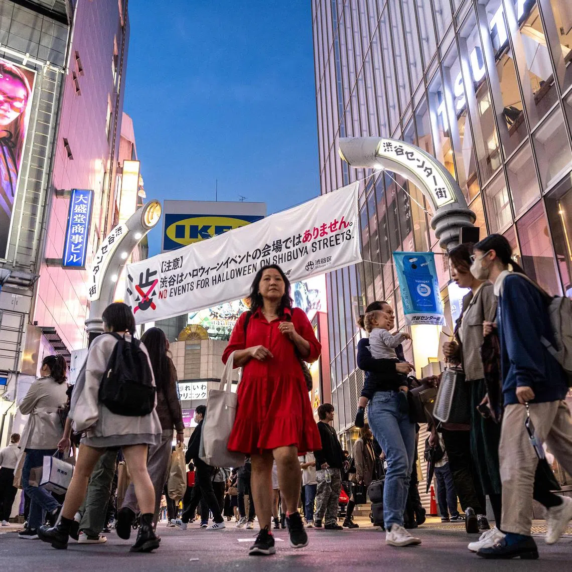 Pedestrians walk at Shibuya Crossing, one of the busiest intersections in the world, as local government asking public to refrain from celebrating Halloween there, in the Shibuya district of Tokyo on October 27, 2023. A ban on alcohol came into force around Tokyo's tourist hotspot Shibuya on October 27 in an attempt to discourage raucous Halloween gatherings a year after a deadly tragedy in South Korea. (Photo by Philip FONG / AFP)