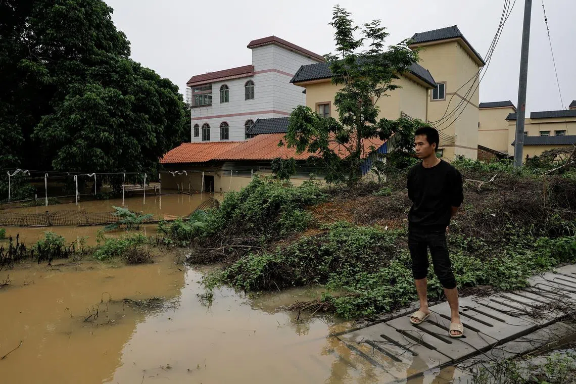 A resident looks on as he stands near houses that are submerged in floodwaters following heavy rainfall at  Xiashahe village, in Qingyuan, Guangdong province, China, on April 22, 2024. 