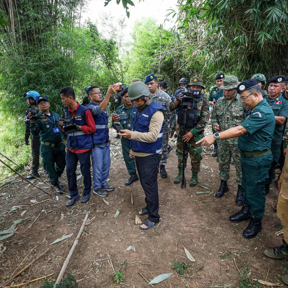 This handout photo taken and released by Agence Kampuchea Press (AKP) on Nov 13, 2025 shows a delegation from the ASEAN Observer Team (AOT) visiting an area where a civilian was killed a day before along the Cambodia-Thailand border.