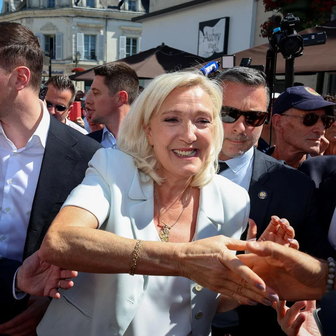 French far-right party Rassemblement National party leader Marine Le Pen (centre) arrives with party president Jordan Bardella (left) for a campaign gathering on July 8.