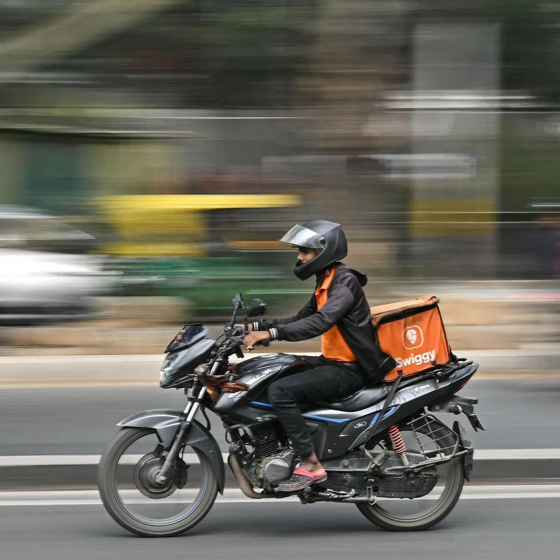A food delivery worker for Swiggy rides along a street in Bengaluru on Jan 6, 2026.
