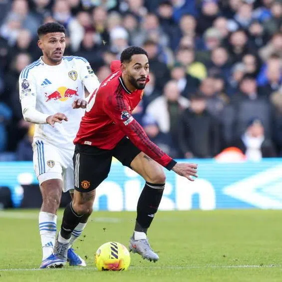 Manchester United's Matheus Cunha shields the ball from Leeds United’s James Justin during the match.