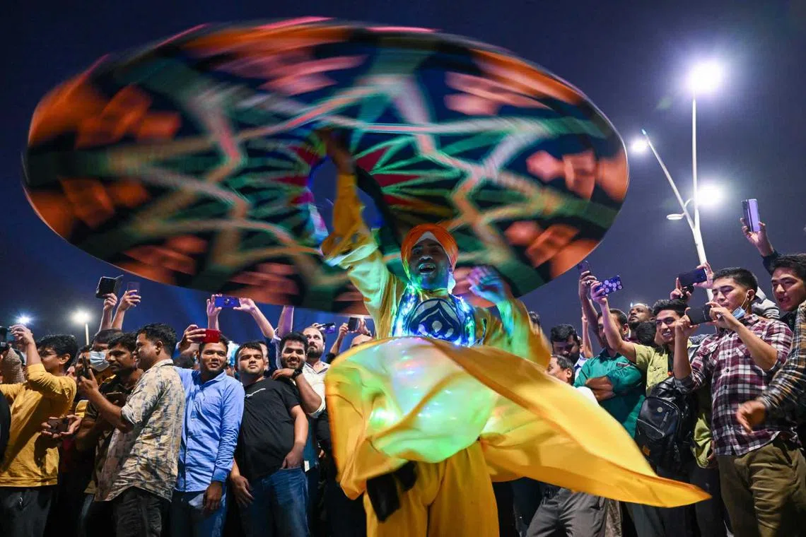 A dancer performs outside of the FIFA Fan Festival at Al Bidda park in Doha on Nov 20, 2022, during the opening of the Qatar 2022 World Cup football tournament. 