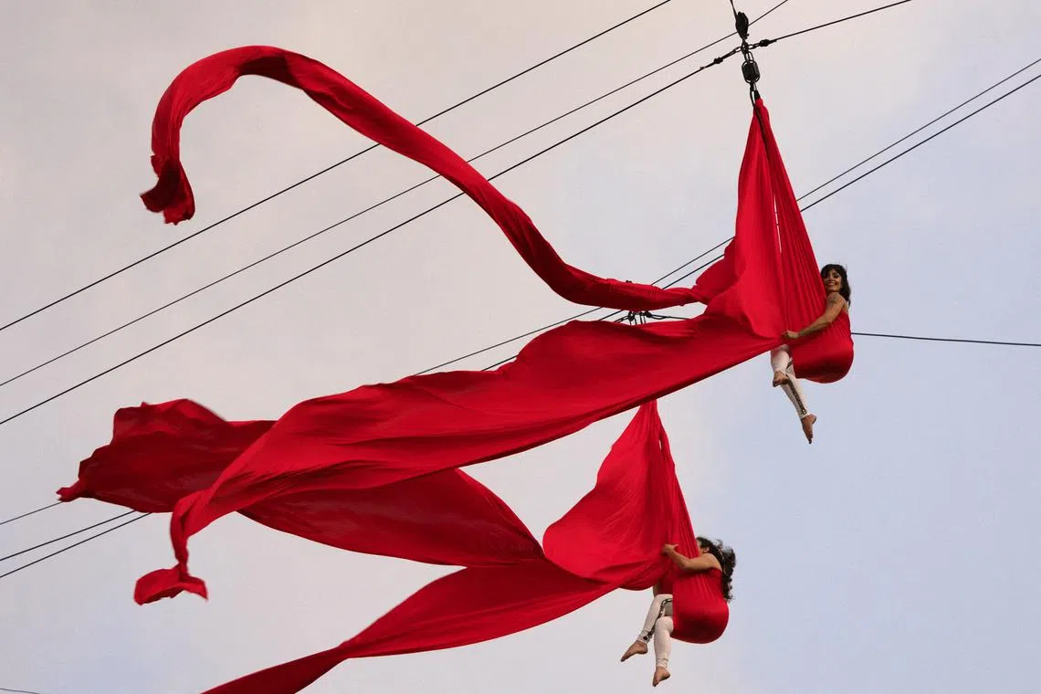 Dancers performing an aerial circus act while suspended from a zipline during the 'Virada Cultural' event in downtown Sao Paulo, Brazil, on May 25, 2025.
