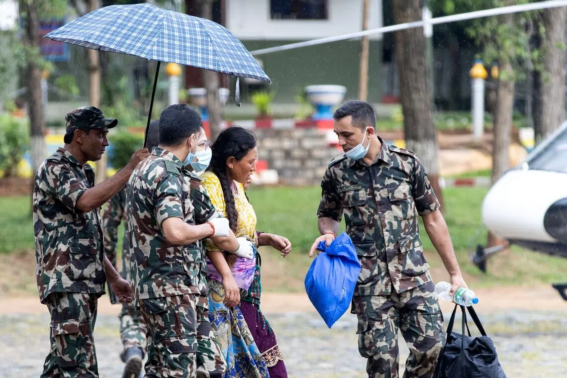 Nepali military personnel evacuating a pregnant woman during rescue operations at Trishuli camp in Nepal’s Nuwakot district on Aug 28, 2026.