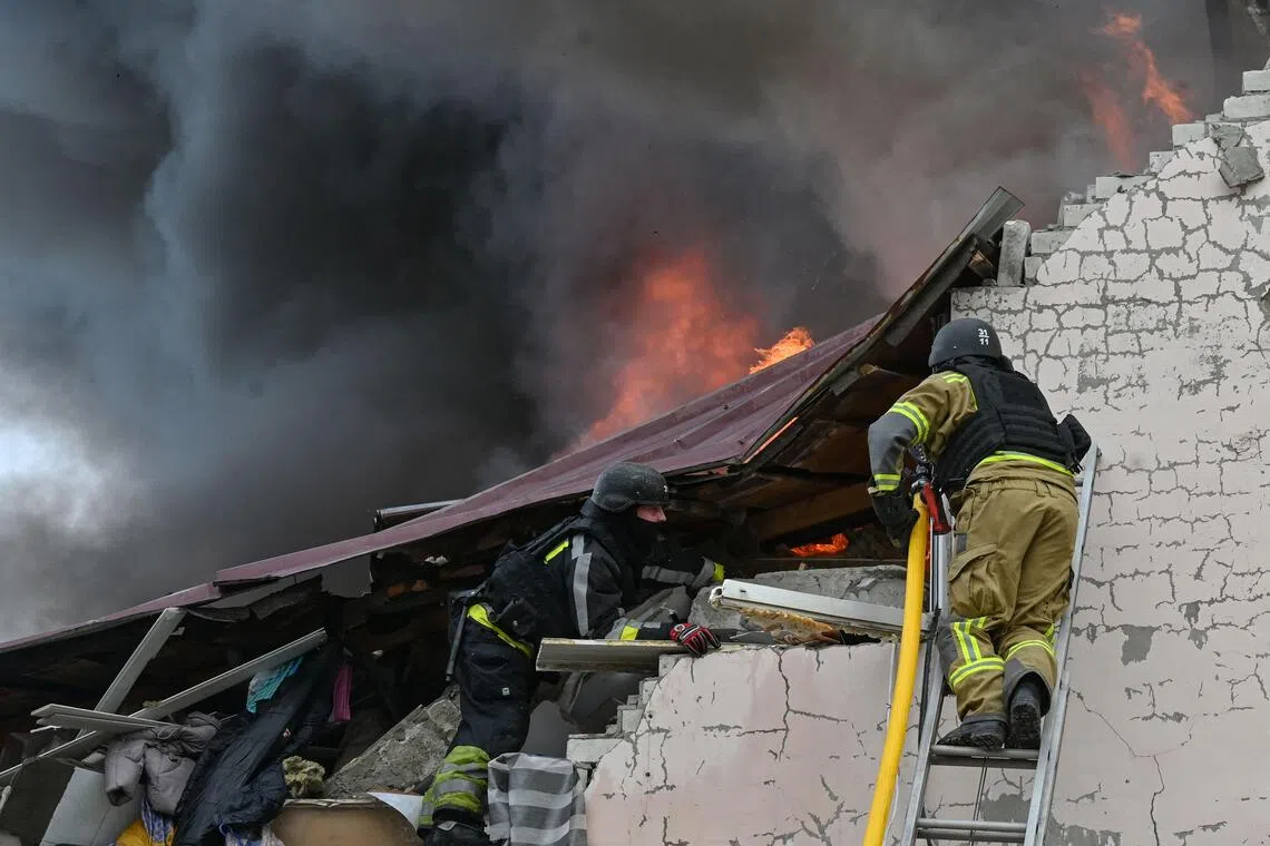 Ukrainian firefighters working at the scene of a Russian air strike on a car repair workshop in Kharkiv on Oct 5.