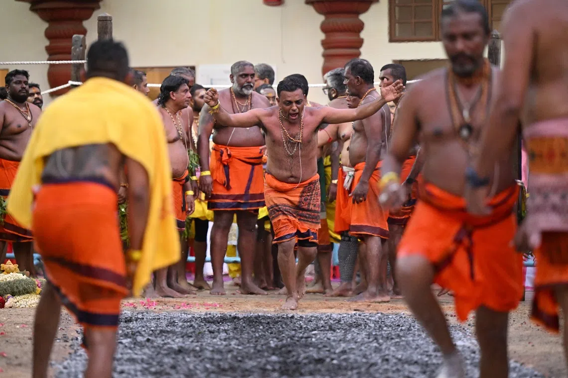 Devotees crossing the fire pit at Sri Mariamman Temple during the annual theemithi vizha, or fire walking festival, on Oct 12, 2025. 