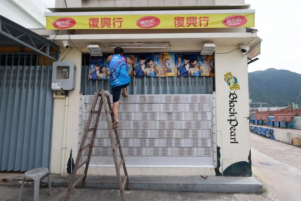 epa12399143 A man places flood barriers in front of his door as a precautionary measure against damage as Typhoon Ragasa approaches in Hong Kong, China, 23 September 2025. Typhoon Ragasa, the world's most powerful tropical typhoon this year, is heading towards Hong Kong. Hong Kong closed schools and called off flights on Tuesday, while authorities in mainland China activated emergency responses to shut businesses and schools in at least 10 cities.  EPA/MAY JAMES