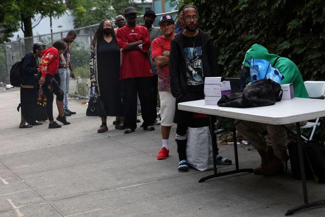 FILE PHOTO: People wait in line to take a COVID-19 oral swab test on a sidewalk in the Harlem neighborhood of New York City, U.S., June 20, 2023.  REUTERS/Shannon Stapleton/File Photo