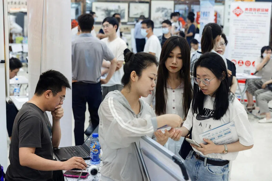 FILE PHOTO: People attend a job fair in a mall in Beijing, China June 30, 2023. REUTERS/Thomas Peter/File Photo