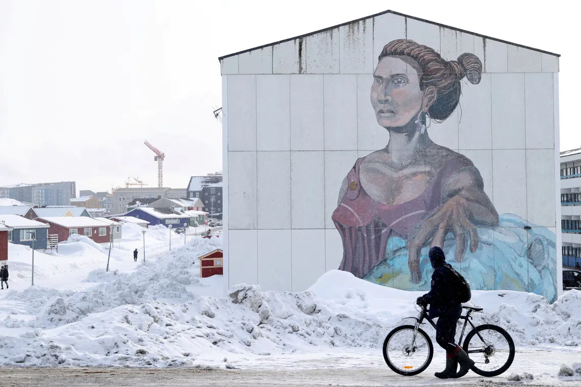 A man passes a building with social housings with an Inuit mural in Nuuk, Greenland, March 27, 2025. REUTERS/Leonhard Foeger