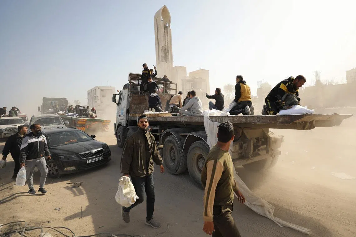 Palestinians transport bags of flour on the back of trucks as humanitarian aid arrives in Gaza City on March 6.