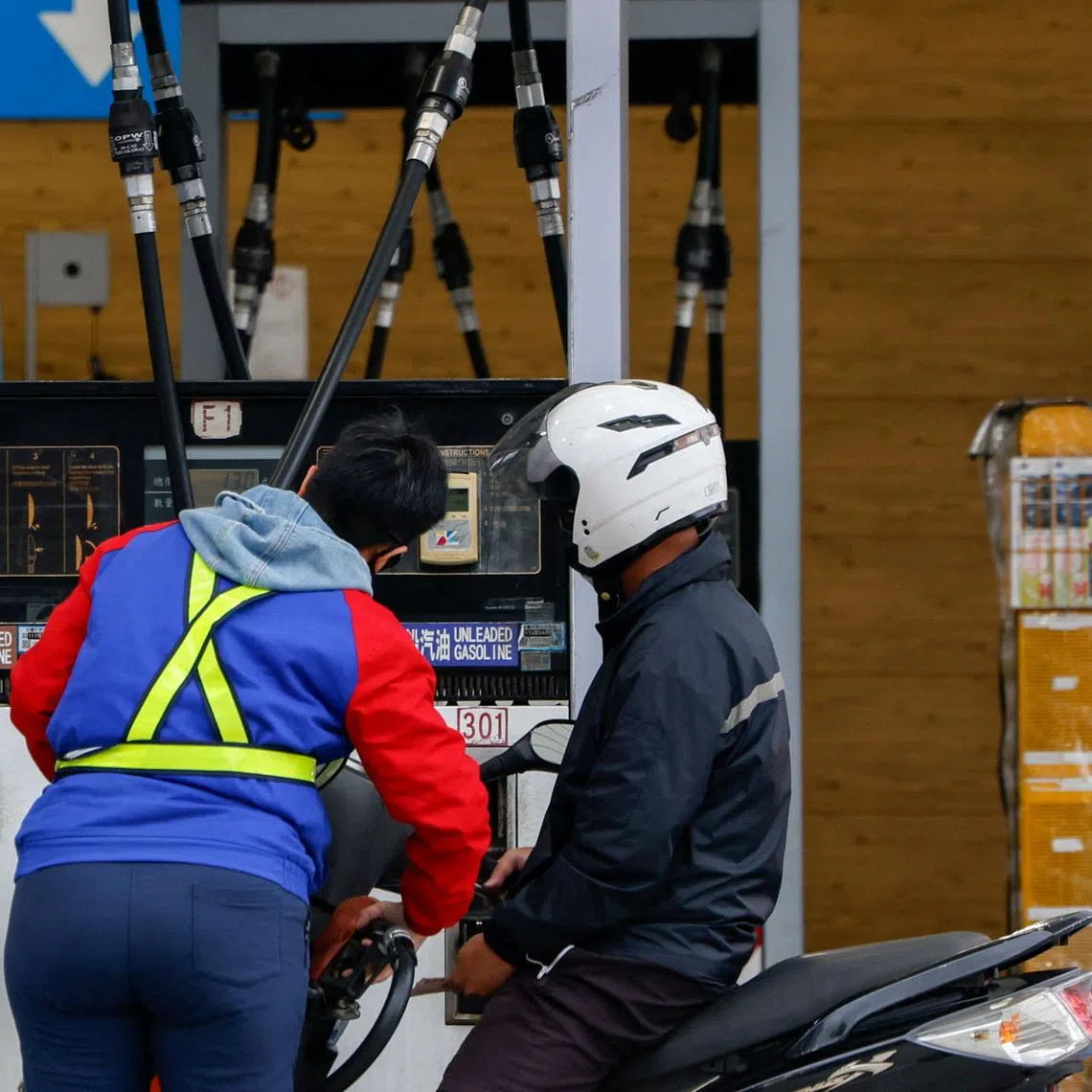 A staff member refuels a motorbike at a gas station in Taipei, Taiwan, on March 9.