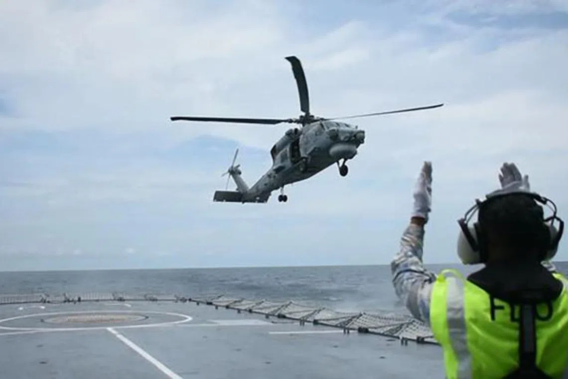 The Singapore S-70B naval helicopter conducted a cross-deck landing on the Malaysian navy ship KD Lekiu.