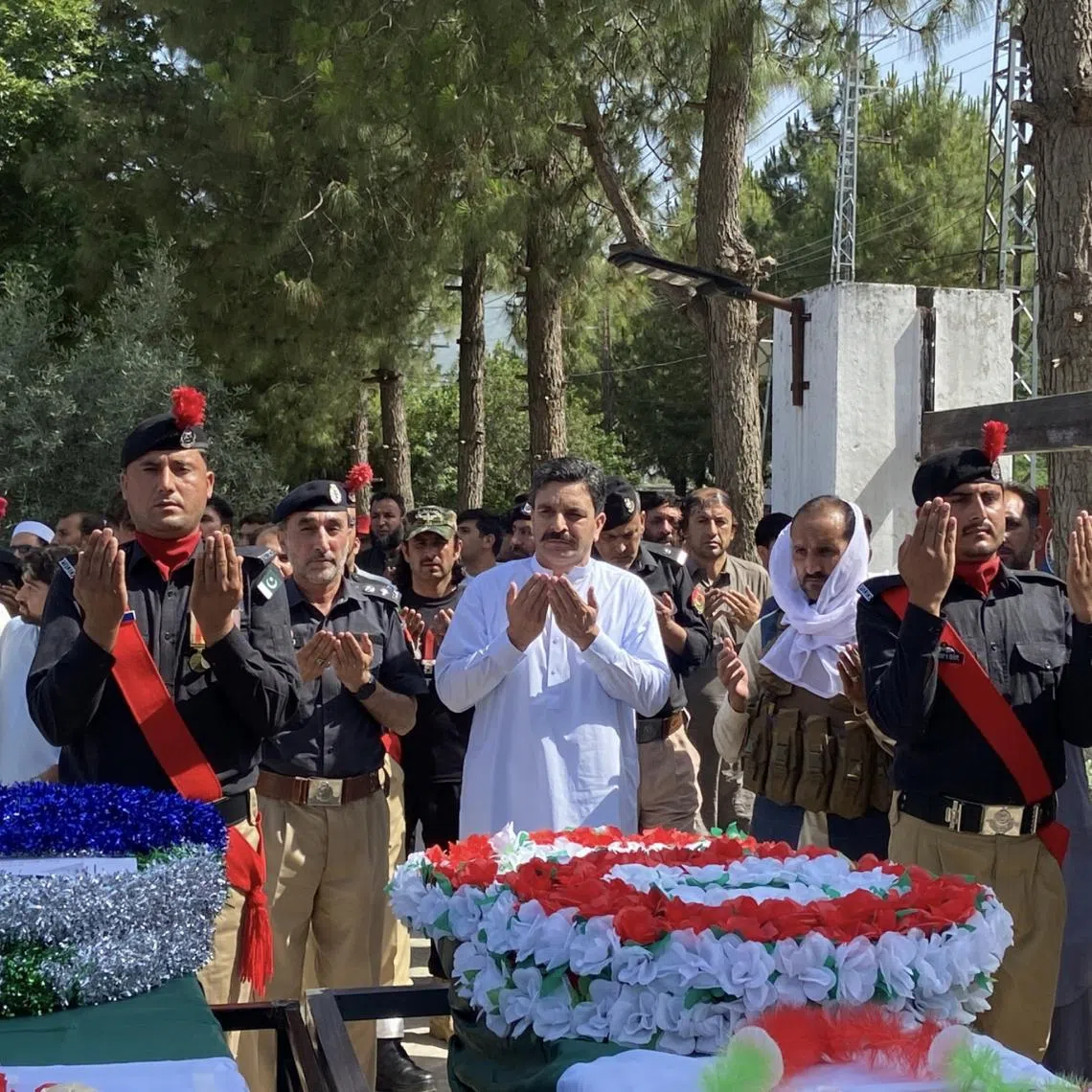 Police officials and relatives attend the funeral of police officers killed while escorting a polio vaccination team in Bajaur, Pakistan, on 18 May.