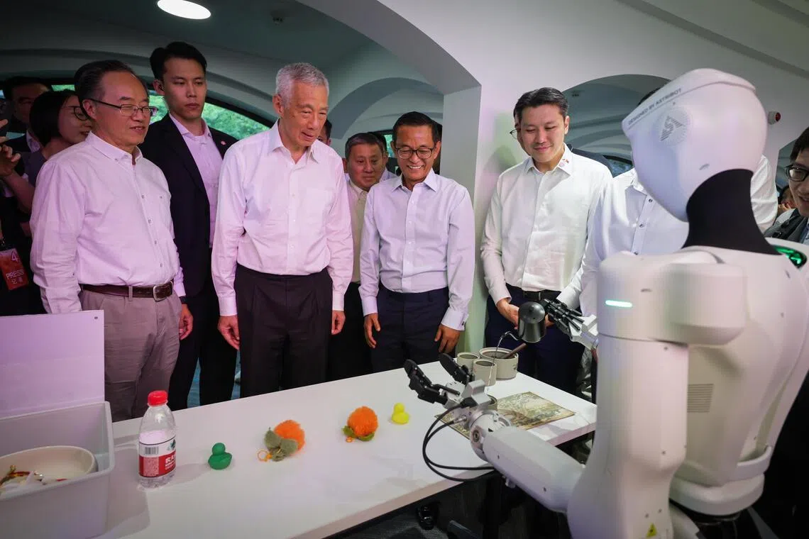 Senior Minister Lee Hsien Loong being served a freshly brewed cup of tea by a humanoid robot imbued with AI smarts.