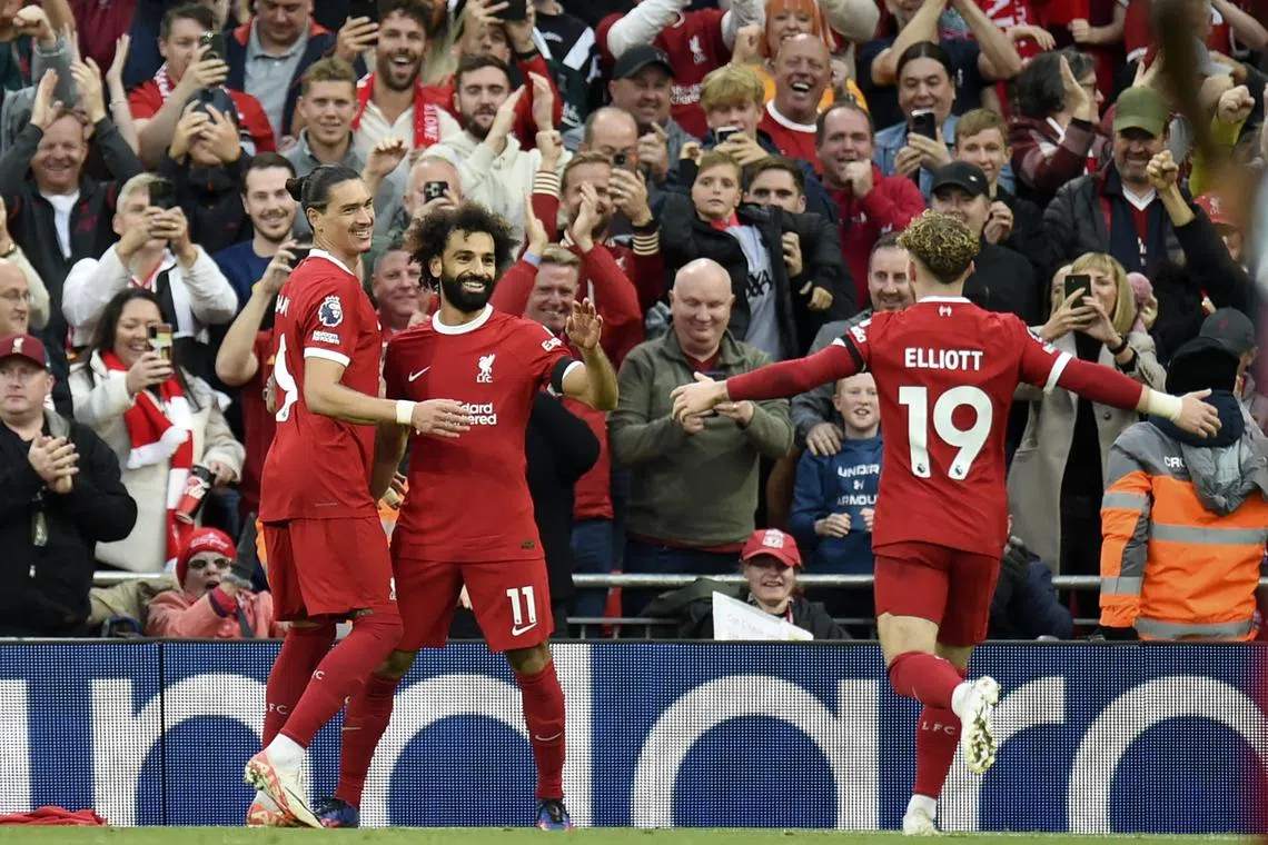 Mohamed Salah of Liverpool celebrates with teammates Darwin Nunez and Harvey Elliott after scoring a goal.