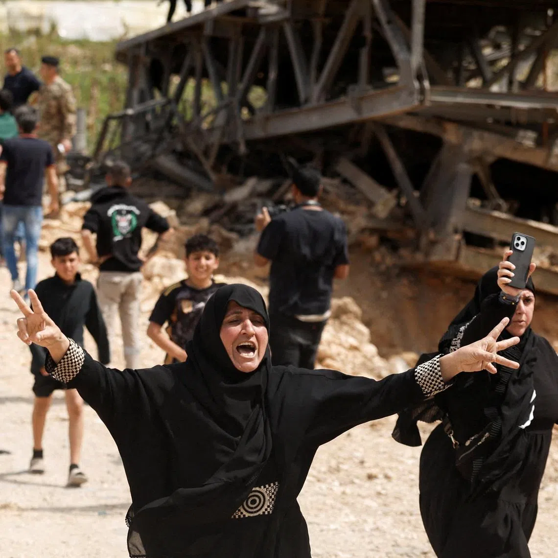 People celebrate as those displaced made their way home crossing the bridge linking southern Lebanon to the rest of the country.