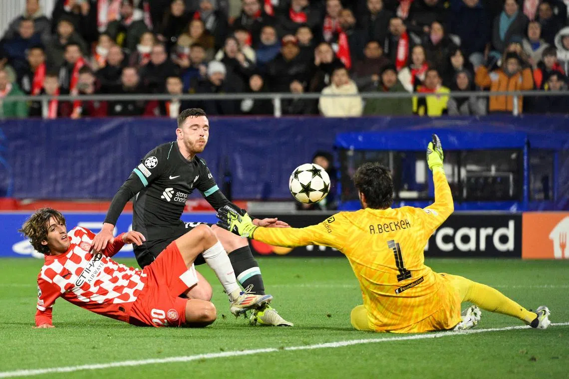 Girona's Bryan Gil, Liverpool's Andrew Robertson and Alisson Becker vie for the ball during their Champions League clash.