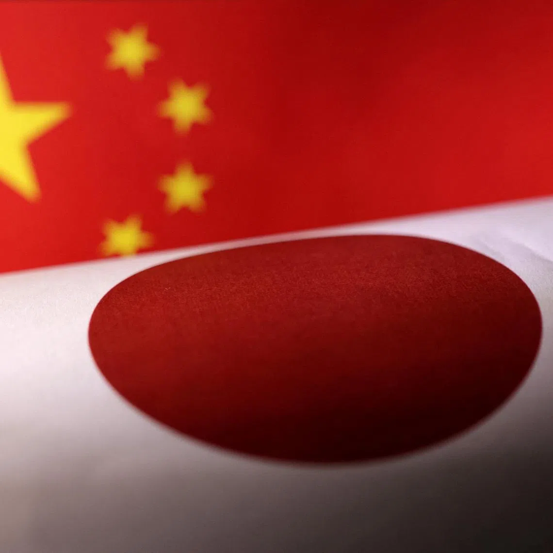 Printed Chinese and Japanese flags are seen in this illustration, July 21, 2022. REUTERS/Dado Ruvic/Illustration