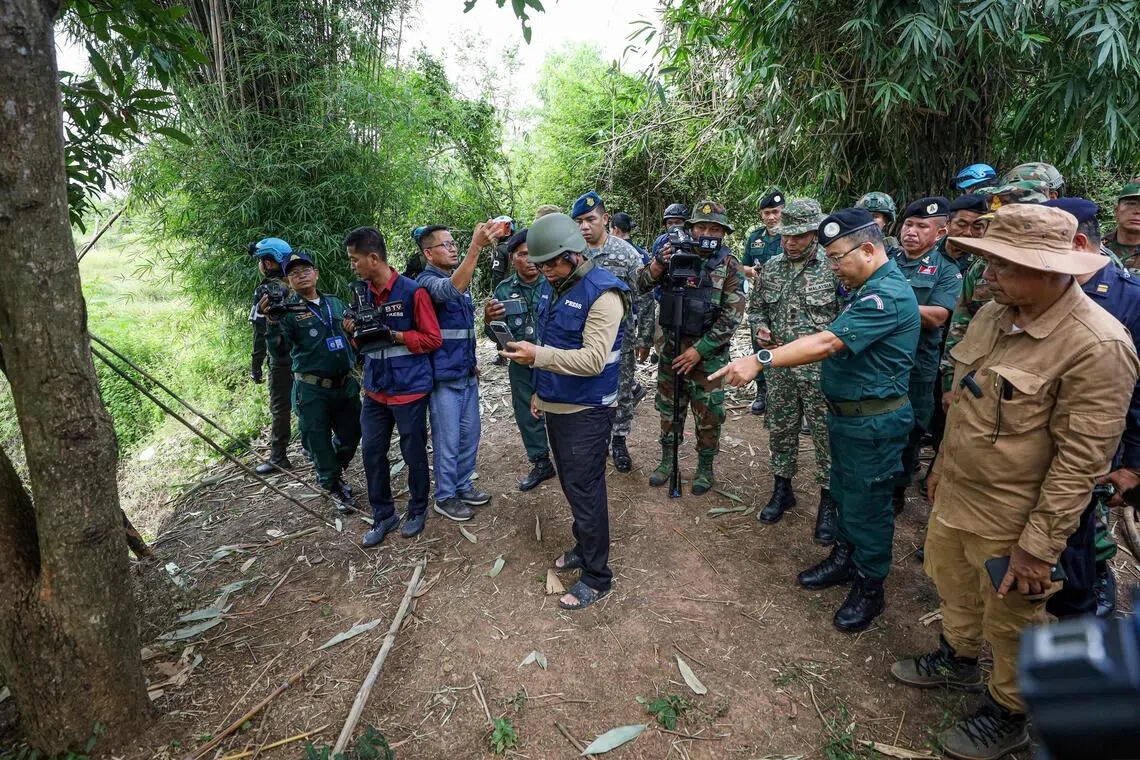 This handout photo taken and released by Agence Kampuchea Press (AKP) on Nov 13, 2025 shows a delegation from the ASEAN Observer Team (AOT) visiting an area where a civilian was killed a day before along the Cambodia-Thailand border.
