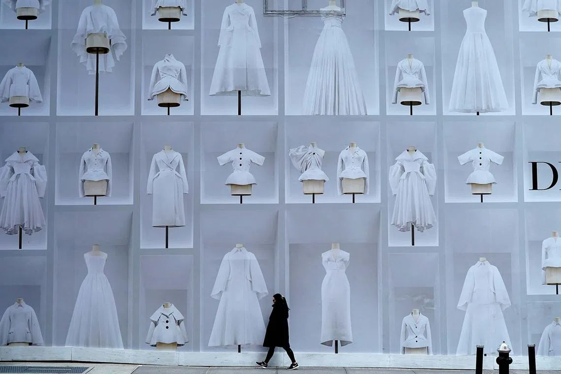 TOPSHOT - A woman walks past the holiday display of the Dior 57th Street store in New York on December 11, 2023. (Photo by TIMOTHY A. CLARY / AFP)