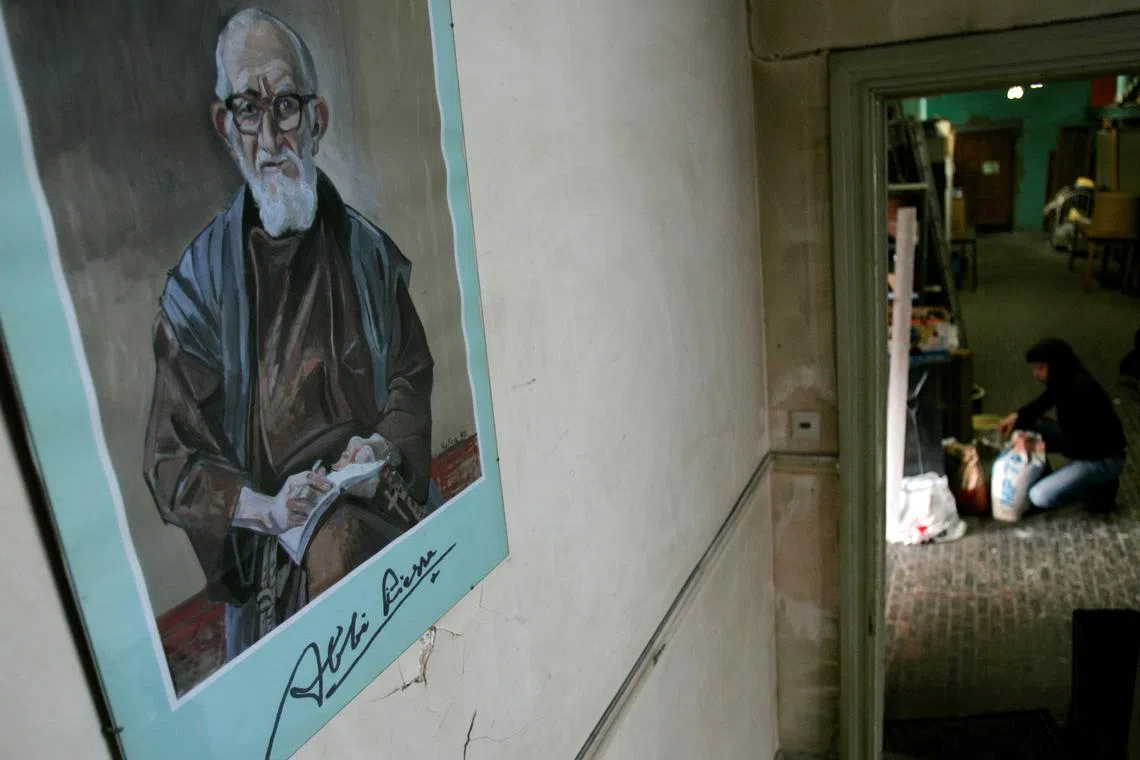 FILE PHOTO: A portrait of French priest Abbe Pierre hangs on a wall at \"La poudriere\" centre, an association that is part of \"Emmaus International\" which helps poor people, in Brussels January 22, 2007. REUTERS/Francois Lenoir/File Photo